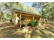 Tan house exterior with a porch, wooden railings, and surrounding trees at 9442 Cr 674, Bushnell, FL 33513