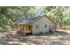 Tan house exterior with a large wrap-around porch and surrounding trees at 9442 Cr 674, Bushnell, FL 33513