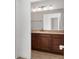 Bathroom with dark wood vanity, tile flooring and a large mirror at 1429 Bluebeard Ct, The Villages, FL 32163