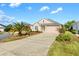 One-story house with a two-car garage and palm trees at 1429 Bluebeard Ct, The Villages, FL 32163
