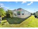 Tan house with a large backyard and sunroom at 1429 Bluebeard Ct, The Villages, FL 32163
