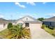 One-story house with a two-car garage and palm tree at 1429 Bluebeard Ct, The Villages, FL 32163