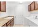 Laundry room with washer, dryer, sink, and wood cabinets at 1429 Bluebeard Ct, The Villages, FL 32163