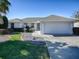 White single-story home with a two-car garage and landscaped front yard at 17799 Se 125Th Cir, Summerfield, FL 34491