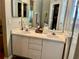 Double vanity bathroom with white cabinets and a large mirror at 5006 El Destino Dr, Leesburg, FL 34748