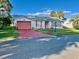 House exterior featuring a peach-colored garage door and red driveway at 5006 El Destino Dr, Leesburg, FL 34748