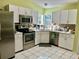 Kitchen with white cabinets, stainless steel appliances, and tile flooring at 5006 El Destino Dr, Leesburg, FL 34748