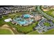 Aerial view of community with resort-style pool, expansive green areas, and numerous homes at 8844 Cruden Bay Ct, Davenport, FL 33896