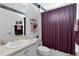 Clean bathroom with a white vanity, purple shower curtain, and a toilet at 1006 Sayle St, The Villages, FL 32162