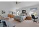 Main bedroom with dresser, large bed, and seating area at 1006 Sayle St, The Villages, FL 32162
