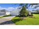 Single-story house with a white exterior, two-car garage, and a beautifully landscaped yard at 1006 Sayle St, The Villages, FL 32162