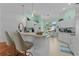 White kitchen features a breakfast bar, light-colored countertops, and hardwood floors at 1006 Sayle St, The Villages, FL 32162
