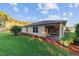 Tan house exterior with screened patio and well-manicured yard at 10286 Julia Isles Ave, Oxford, FL 34484