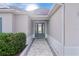 Front entry with a gray door and a brick walkway at 1102 Ivawood Way, The Villages, FL 32163