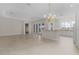 Kitchen with island, white cabinets, and view to living area at 1102 Ivawood Way, The Villages, FL 32163