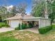 Single car garage with covered carport and mature landscaping at 11036 Cr 229, Oxford, FL 34484