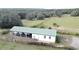 Aerial view of a long white barn with a green roof at 13131 Mountain Vw, Clermont, FL 34715