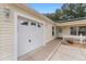 House exterior with a white two-car garage and a side entrance at 1612 Staunton St, The Villages, FL 32162