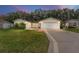 Inviting yellow home with a 2-car garage and well-manicured lawn at 1612 Staunton St, The Villages, FL 32162