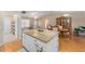 Open concept kitchen and dining area with granite island at 1612 Staunton St, The Villages, FL 32162