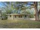 Tan single story house with a spacious yard and large oak trees at 34929 Cutoff Rd, Fruitland Park, FL 34731