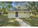 Light beige guest house with screen door and window at 34929 Cutoff Rd, Fruitland Park, FL 34731