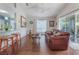 Living room with hardwood floors, a brown leather couch, and access to a patio at 4130 Capland Ave, Clermont, FL 34711
