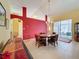Dining room with red accent wall, wooden table, and access to the lanai at 4634 Summerbridge Cir, Leesburg, FL 34748