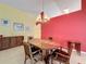Formal dining room featuring a wood table and red accent wall at 4634 Summerbridge Cir, Leesburg, FL 34748