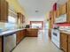 Open kitchen with view to dining area, wood cabinets, and tile floors at 4634 Summerbridge Cir, Leesburg, FL 34748