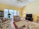 Living room with vaulted ceiling, tiled floors, and access to a screened lanai at 4634 Summerbridge Cir, Leesburg, FL 34748