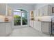 White kitchen with built-in shelving and large window overlooking backyard at 4878 Chitty Chatty Run, The Villages, FL 32163