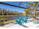 Two Adirondack chairs on a patio overlooking a lake at 4878 Chitty Chatty Run, The Villages, FL 32163