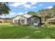 Spacious backyard with screened patio, lush lawn, and mature trees at 5533 Grove Mnr, Lady Lake, FL 32159