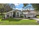 Single-story home with a two-car garage and landscaped yard at 5533 Grove Mnr, Lady Lake, FL 32159