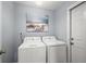 Laundry room with washer, dryer, and beach-themed wall art at 5533 Grove Mnr, Lady Lake, FL 32159