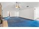 Large living room featuring high ceilings, a ceiling fan, and blue carpet at 7921 Jacksons River Rd, Leesburg, FL 34788