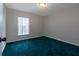 Bright bedroom featuring teal carpet and window at 2117 Nicollett Way, Leesburg, FL 34748