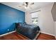Comfortable bedroom with blue accent wall and ceiling fan at 29549 Caspian St, Leesburg, FL 34748