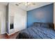 Bedroom with blue accent wall, ceiling fan, and mirrored closet doors at 29549 Caspian St, Leesburg, FL 34748