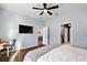 Bright bedroom with hardwood floors, a large TV, and en-suite bathroom at 29549 Caspian St, Leesburg, FL 34748