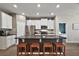 Kitchen island with seating and dark countertops, open to living area at 29549 Caspian St, Leesburg, FL 34748