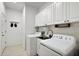 Bright laundry room with washer, dryer, and ample cabinetry at 29549 Caspian St, Leesburg, FL 34748