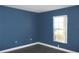 Blue bedroom with a window, closet, and hardwood floors at 3211 Lupine Way, Lake Wales, FL 33898