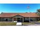 Community clubhouse with brown roof, stone accents, and flagpole at 3211 Lupine Way, Lake Wales, FL 33898