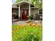 Inviting front entrance with red door and flower garden at 32628 Gere Ln, Sorrento, FL 32776