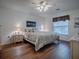 Spacious bedroom with wood flooring, a ceiling fan, and ample natural light at 33236 Grand Cypress Way, Leesburg, FL 34748