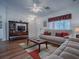 Comfortable living room with hardwood floors, neutral-toned furniture, and a TV stand at 33236 Grand Cypress Way, Leesburg, FL 34748