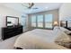 Bedroom with king bed, dresser, and three windows at 409 Alcove Dr, Groveland, FL 34736