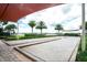 Outdoor bocce ball courts under shade structures with palm trees in the background at 409 Alcove Dr, Groveland, FL 34736